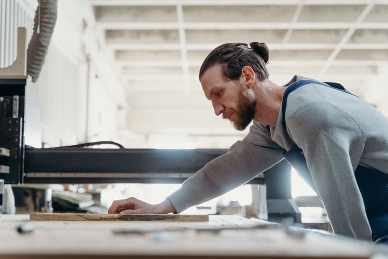 Handwerker bedient eine Maschine in einer Werkstatt